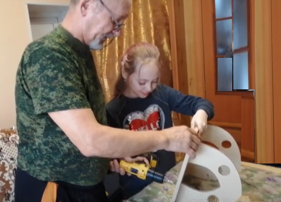 дедушка и внучка дружно делают кормушку для птиц